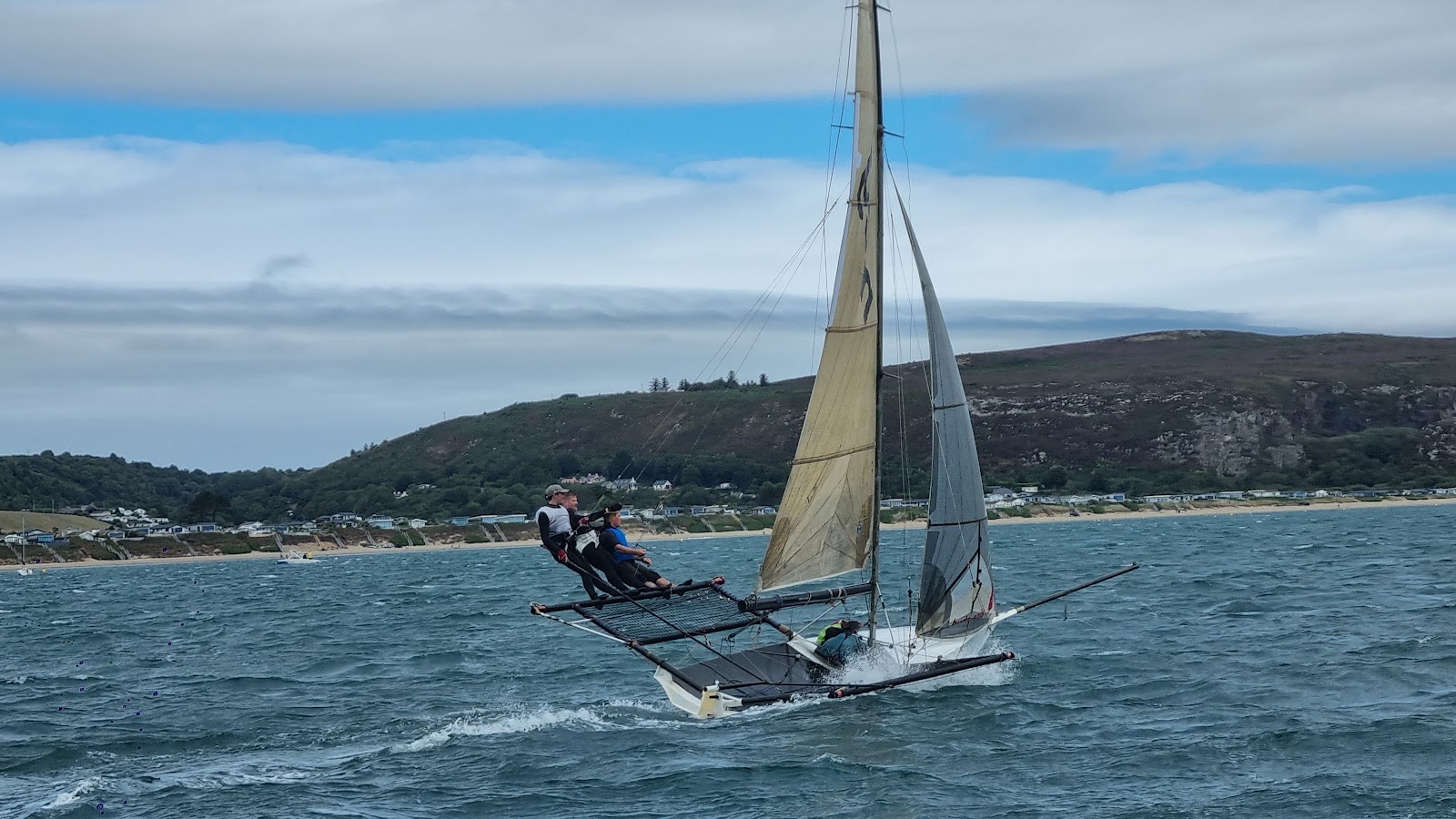 Beomus at speed under a blue sky, both crew out on the wings