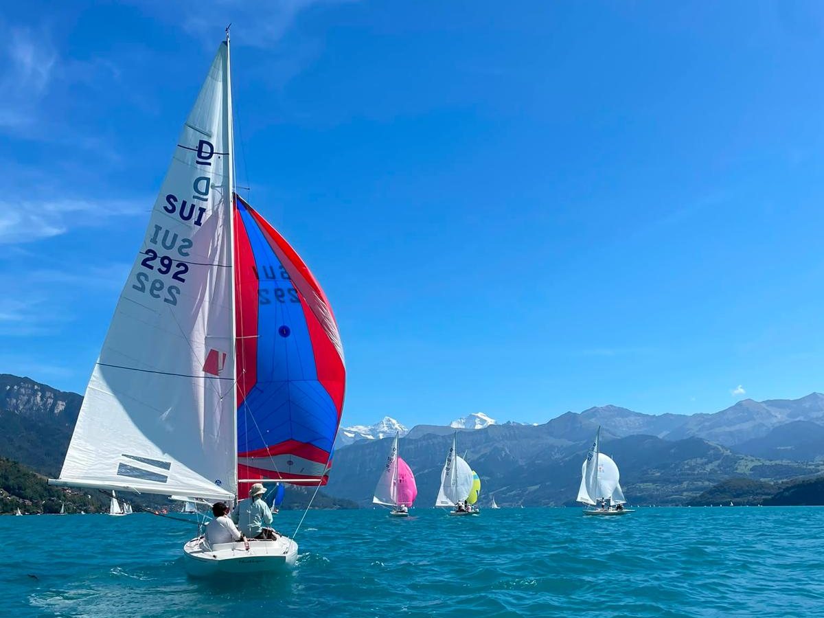 Mustique, SUI 292, under a red and blue spinnaker on a Swiss lake, other Dragons and the Alps behind